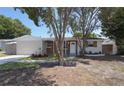 Single-story home with a brick exterior, front yard, and trees at 8391 76Th Ave, Seminole, FL 33777