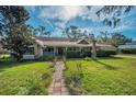 Picture-perfect home exterior with a lush lawn and a clear blue sky at 1055 Riverside Ridge Rd, Tarpon Springs, FL 34688