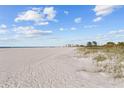 Expansive beach view with white sand and blue sky at 1200 Gulf Blvd # 206, Clearwater, FL 33767