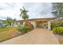 Front exterior of home with covered carport and lush landscaping at 2003 Halmrock Pl, Sun City Center, FL 33573