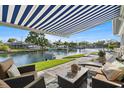 Relaxing patio area with seating under a striped awning, overlooking the water at 5101 Huntington Ne Cir, St Petersburg, FL 33703