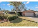 Brick ranch home with attached garage and mature landscaping at 7400 Locust Ne St, St Petersburg, FL 33702