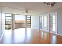 Spacious living room features a ceiling fan, hardwood floors, and glass doors leading to a private balcony at 7400 Sun Island Dr # 501, South Pasadena, FL 33707