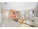 Living room with tiled floors, floral couch, and light wood coffee table at 9125 41St N St, Pinellas Park, FL 33782