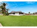 Side view of a single-story home showcasing its exterior and landscaped yard at 1402 Seton Hall Dr, Sun City Center, FL 33573