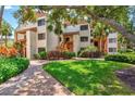 Attractive condo building exterior with lush landscaping and brick walkways at 1700 Cove Ii Pl # 310, Sarasota, FL 34242