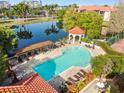 Community pool with lounge chairs, a covered area, and landscaping at 2400 Feather Sound Dr # 515, Clearwater, FL 33762