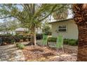 Relaxing backyard patio with two chairs under a tree at 628 Pine St, Tarpon Springs, FL 34689