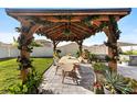 Relaxing backyard with covered pergola, dining area, and lush green lawn at 9334 Lemon Drop Loop, Sun City Center, FL 33573