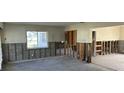 Open-concept living room features large window, concrete floors, and exposed wall framing at 15816 2Nd St E, Redington Beach, FL 33708