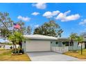 Light blue home with a white garage door and landscaping at 1816 Woodridge Dr, Clearwater, FL 33756