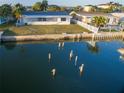 Waterfront home featuring a well-kept lawn, seawall, and proximity to tropical landscaping at 325 173Rd E Ave, North Redington Beach, FL 33708