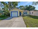 Newly painted yellow house with blue trim, a single car garage, and well-maintained lawn at 7471 35Th N St, Pinellas Park, FL 33781