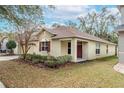 Tan house with red door and landscaping at 10615 Dawns Light Dr, Riverview, FL 33578