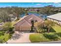 Expansive aerial view of the home, showcasing the lake view, landscaping, and tile roof at 1160 Darlington Oak Ne Dr, St Petersburg, FL 33703