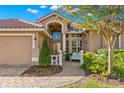 Inviting front entrance with a brick walkway, manicured bushes, and arched window above the door at 1160 Darlington Oak Ne Dr, St Petersburg, FL 33703