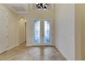 Bright foyer with high ceilings, decorative double doors, and tile floor at 1533 Emerald Dunes Dr, Sun City Center, FL 33573