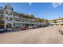 Front view of a light-green building with palm trees and cars parked in front at 2386 Sumatran Way # 34, Clearwater, FL 33763