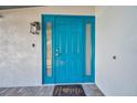 Close-up of the bright teal front door with decorative glass panels at 262 5Th Nw St, Largo, FL 33770