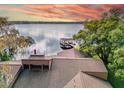 Scenic view of a lakefront home featuring a dock and serene water views at 18120 Wayne Rd, Odessa, FL 33556