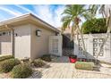 Tan house with attached garage and gated entry, surrounded by palm trees and landscaping at 417 Boca Ciega Point N Blvd # 417, St Petersburg, FL 33708