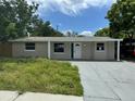 Single-story home with covered entryway, driveway, and some landscaping at 5038 Galaxy Dr, New Port Richey, FL 34652
