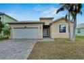 Tan one-story house with a white door and garage at 442 Bahama Grande Blvd, Apollo Beach, FL 33572