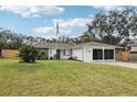 Charming ranch house with stone facade, lush lawn, and American flag at 6168 Applegate Dr, Spring Hill, FL 34606