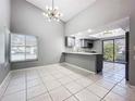 Bright dining area with modern light fixture and view of kitchen at 1836 Cypress Trace Dr, Safety Harbor, FL 34695