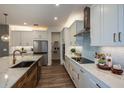 Bright and airy kitchen featuring white cabinets, a pantry, and sleek appliances at 18472 Vista Park Ter, Venice, FL 34293