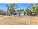 Front yard of a house with a screened porch and palm trees at 569 Dixie Hwy, Tarpon Springs, FL 34689