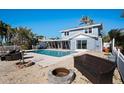 Outdoor pool area with lounge chairs, fire pit and backyard access at 807 Bay Point Dr, Madeira Beach, FL 33708