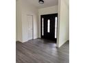 Bright foyer featuring a dark, decorative front door and a convenient coat closet for storage at 12186 Lamont Dr, Spring Hill, FL 34608
