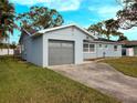 Updated home with a gray garage door and freshly cut lawn at 1817 Oregon Ne Ave, St Petersburg, FL 33703