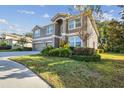 Two-story house with three-car garage, lush landscaping at 2212 Valterra Vista Way, Valrico, FL 33594