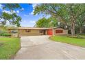 Home exterior view, featuring a long driveway and landscaping at 3703 Perdew Dr, Land O Lakes, FL 34638