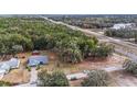 Aerial view of a property surrounded by trees near a highway at 5250 Little Green Ln, Dade City, FL 33523