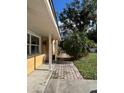 Side view showcasing a walkway leading to the entrance of a charming yellow house at 8823 W Robson St, Tampa, FL 33615