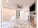 Living room with a ceiling fan, fireplace, and sliding barn door at 9100 Dr Martin Luther King Jr N St # 1706, St Petersburg, FL 33702