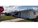 Attractive single-story home with an attached garage and nicely landscaped front yard at 9350 Mainlands W Blvd, Pinellas Park, FL 33782