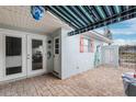 Outdoor patio with brick pavers, striped awning, and access to the interior at 127 Boca Ciega Point N Blvd, St Petersburg, FL 33708