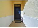Dark wood front door with storm door and entry mat at 17766 Garsalaso Cir, Brooksville, FL 34604