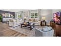 Open living room with white sofas, a coffee table, and a large TV at 5009 Rocky Coast Pl, Palmetto, FL 34221