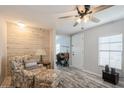 Living room with floral armchair, wood accent wall, and ceiling fan at 233 Tarpon Ln, Oldsmar, FL 34677