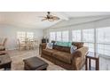 Living room with brown couch, dining table, and large windows at 233 Tarpon Ln, Oldsmar, FL 34677