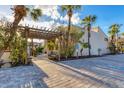 Inviting entryway with pergola, bench, and lush landscaping at 4621 Gulf Of Mexico Dr # D10, Longboat Key, FL 34228