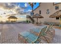Exterior beach area with tiki hut and lounge chairs at 4621 Gulf Of Mexico Dr # D10, Longboat Key, FL 34228