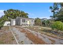 Gray house with yellow door, gravel driveway, and landscaped yard at 4809 11Th S Ave, St Petersburg, FL 33711
