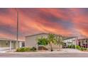 Mobile home with carport and landscaping; sunset in background at 8624 Fantasia Park Way, Riverview, FL 33578