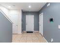 Townhome foyer features neutral tile flooring, a staircase, and a modern security system at 12827 Buffalo Run Dr, Gibsonton, FL 33534